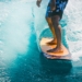 man riding wave with orange surfboard