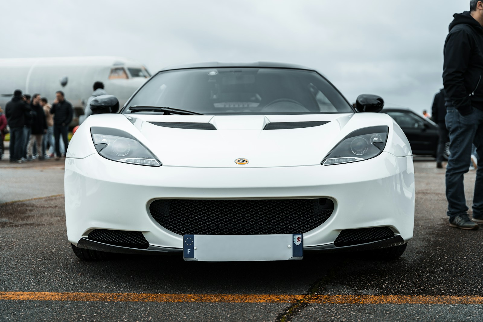 A white sports car parked in a parking lot