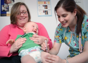 a woman holding a baby in a hospital room