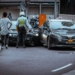 man in white and black stripe shirt and black pants standing beside black car during daytime