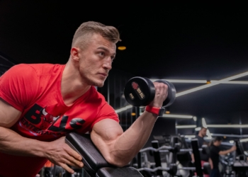 a man in a gym holding a dumbbell
