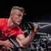 a man in a gym holding a dumbbell