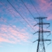 black electric pylon under orange clouds during daytime
