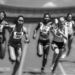 Female athletes in a high-stakes track race showcasing physical prowess and competition.