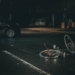 grey bicycle on road near black vehicle at nighttime