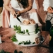 woman in white dress holding white and blue floral ceramic bowl with food