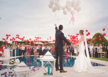 photo of a man and woman newly wedding holding a balloons
