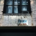 for rent sign on wall below window glass of building