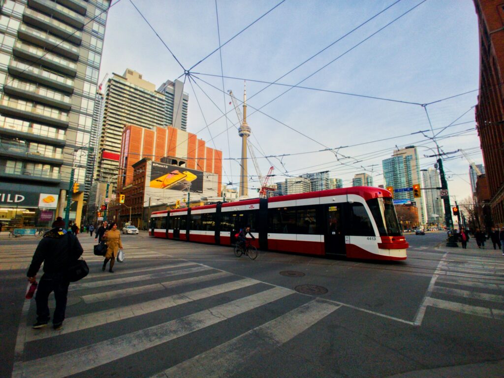 people walking on pedestrian lane beside red and white train