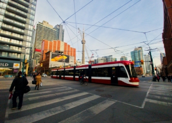 people walking on pedestrian lane beside red and white train