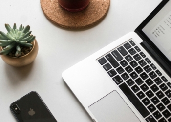 space gray iPhone X beside turned on laptop beside coffee and succulent plant