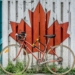 red road bike beside red and white wooden maple leaf painted wall
