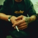 a man sitting down with a cigarette in his hand