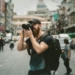 shallow focus photography of man using a DSLR camera