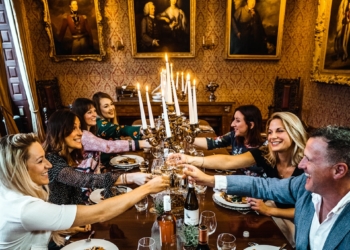 group of people sitting on chair in front of table with plates and drinking glasses