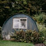 a round building with a window in the middle of a garden