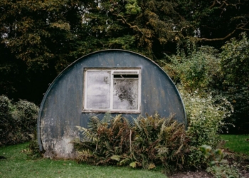 a round building with a window in the middle of a garden