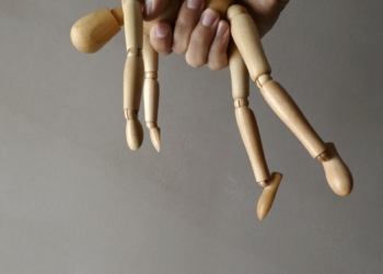 person holding brown wooden mannequin