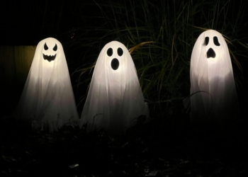 three ghost statues in the dark with their faces glowing