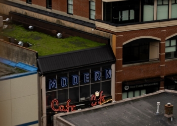 Modern cafe sign on brick building rooftop