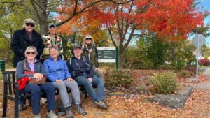 Six people on bench in front of trail