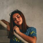 a woman leaning against a railing with her eyes closed