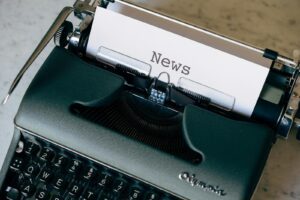 A vintage typewriter with a paper titled 'News', symbolizing journalism and communication.