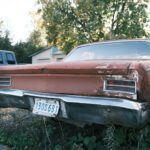 Aged classic car with rust and patina parked outdoors in Gatineau, Quebec, Canada.