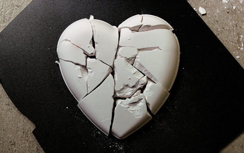 A broken heart shaped cookie sitting on top of a table