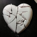 A broken heart shaped cookie sitting on top of a table