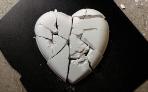 A broken heart shaped cookie sitting on top of a table