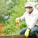 man in white long sleeve shirt and blue denim jeans sitting on brown wooden fence during