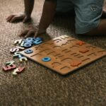 Child playing with alphabet puzzle on carpet