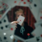 person holding 2 of diamonds playing card