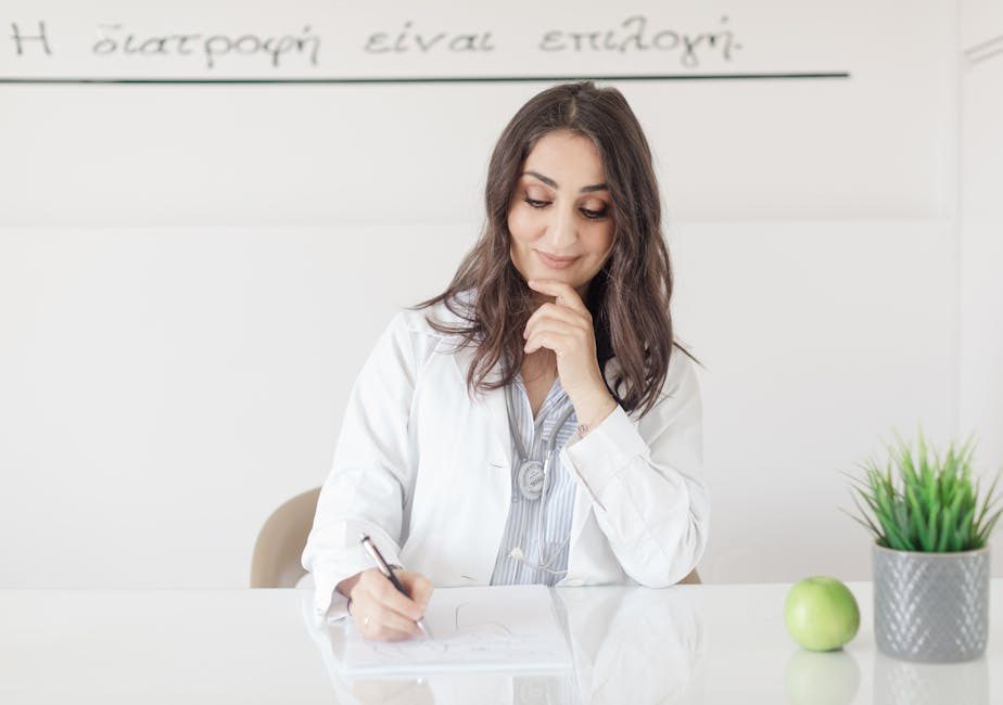 A registered dietitian taking notes during a patient consultation