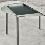 Modern table with unique design and metal legs.