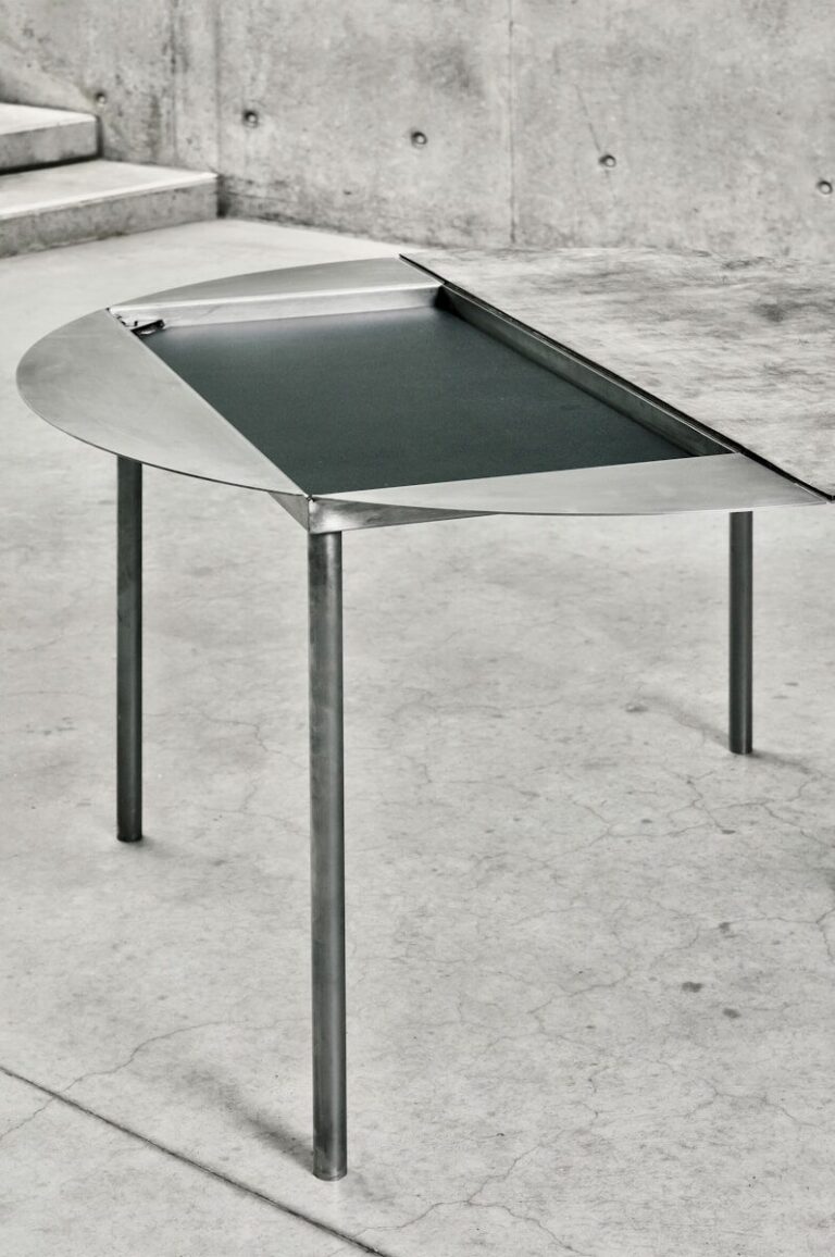 Modern table with unique design and metal legs.