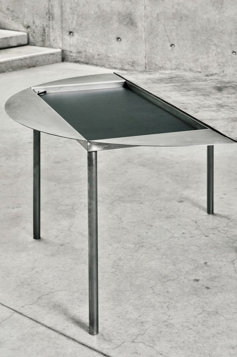 Modern table with unique design and metal legs.