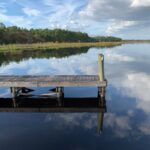 wooden dock and calm body of water