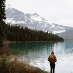a person standing on a shore of a lake