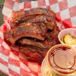 Stack of barbecued ribs with pickles and coleslaw