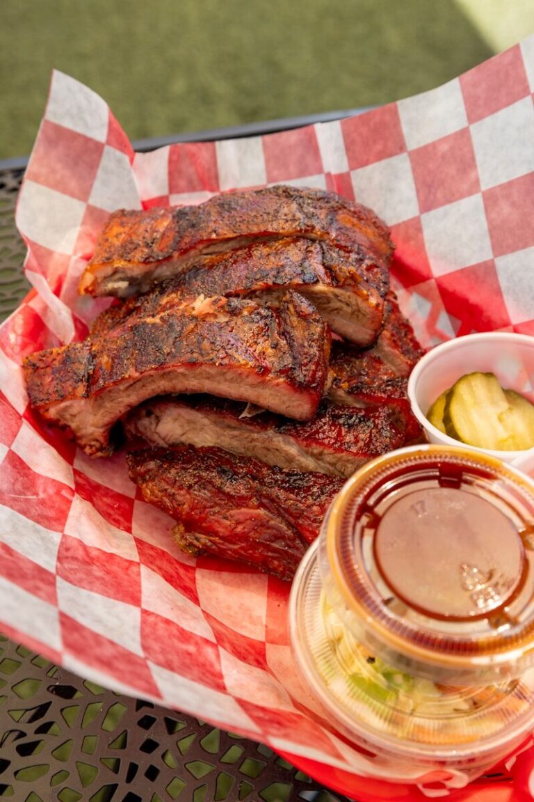 Stack of barbecued ribs with pickles and coleslaw