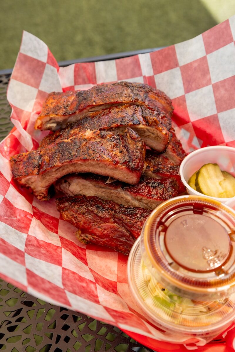 Stack of barbecued ribs with pickles and coleslaw