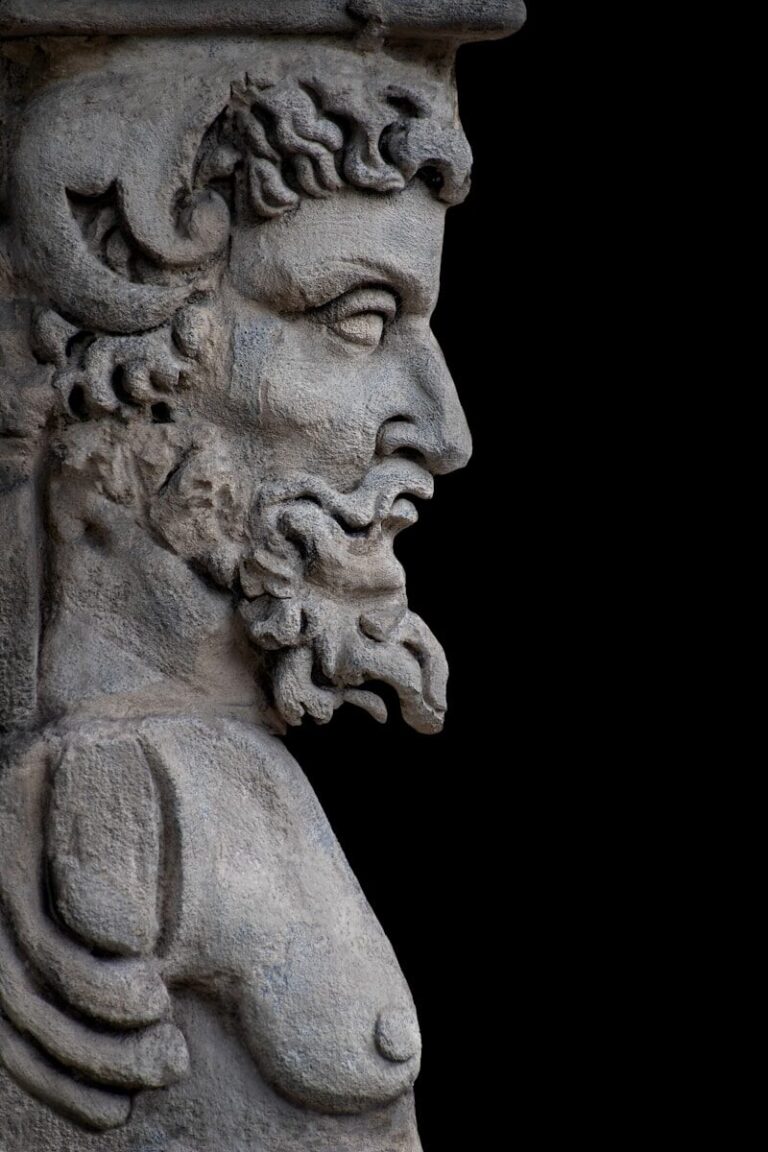 A stone statue of a bearded man in profile.