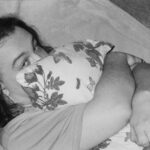 a black and white photo of a woman holding a baby