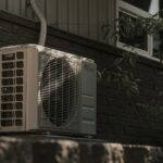 a white air conditioner sitting on top of a brick wall