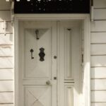 White wooden door with ornate metal details