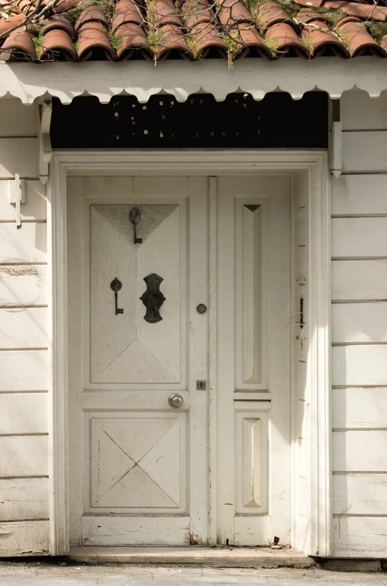 White wooden door with ornate metal details