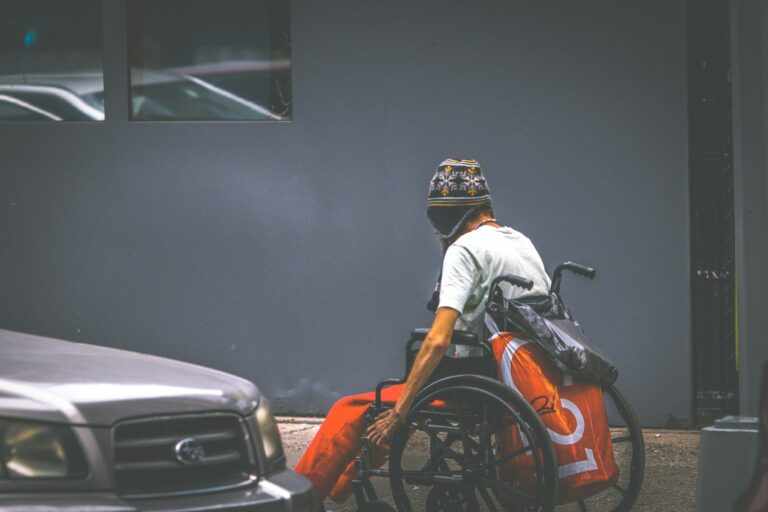 man in white shirt and helmet sitting on orange and black car hood