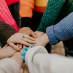 group stacking hands in colorful sweaters